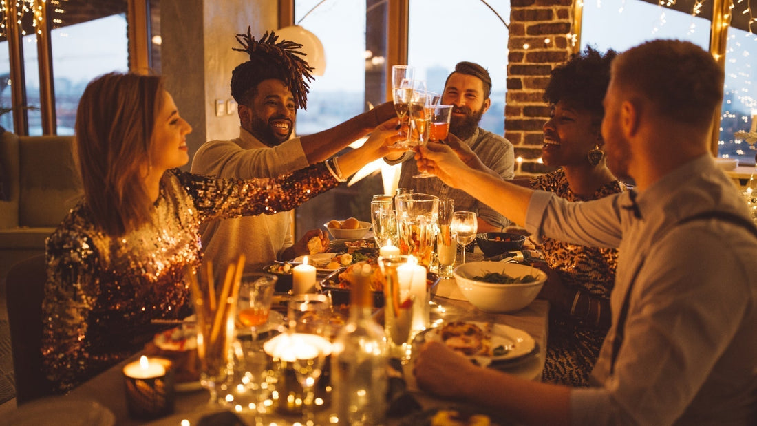 Friends toasting with wine glasses at a candlelit fall dinner party