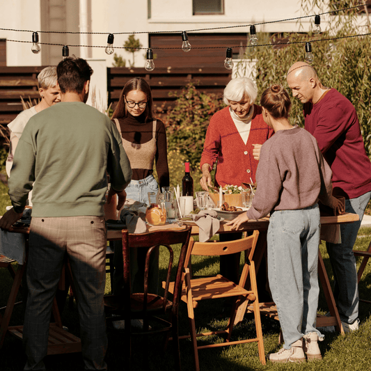 Family enjoying a Memorial Day BBQ with wine pairings and grilled dishes in the backyard