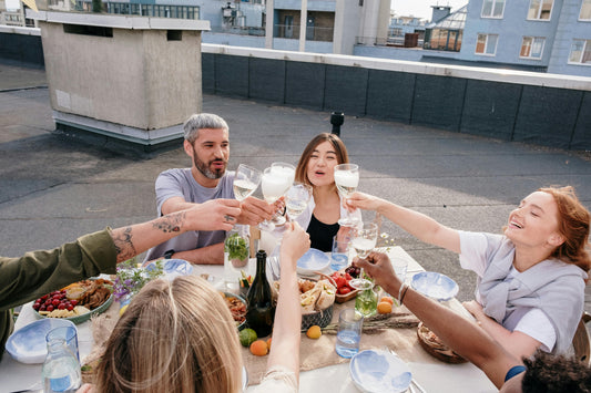 Friends enjoying the best wines in NYC during a rooftop summer gathering, featuring glasses of chilled white wine from a local wine store NYC